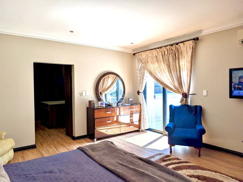 Spacious bedroom featuring laminate flooring, recessed lighting, and a sliding glass door providing access to an outdoor area.