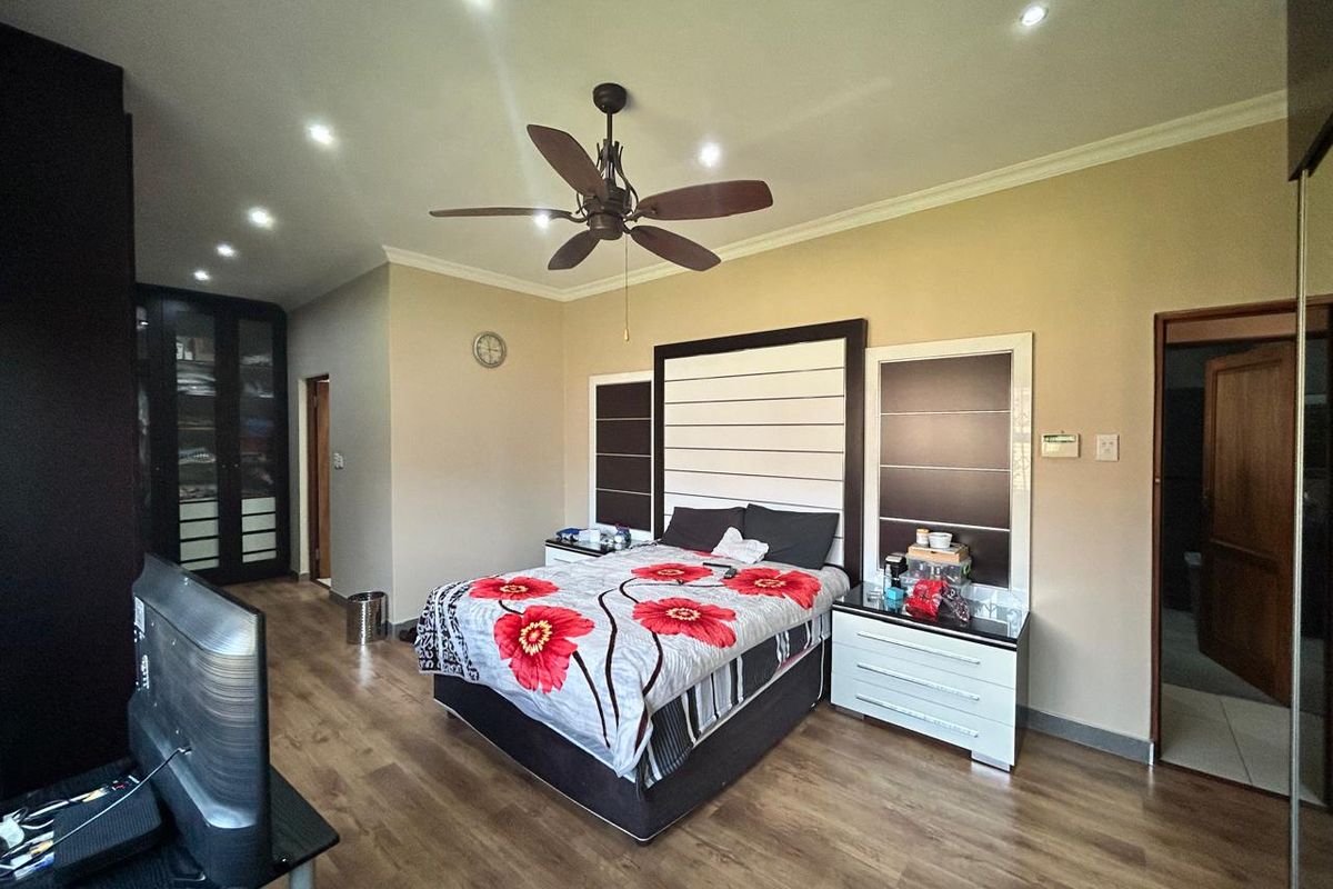 Spacious bedroom featuring wood-look laminate flooring, recessed ceiling lighting, a ceiling fan, and built-in cabinetry with integrated headboard design.