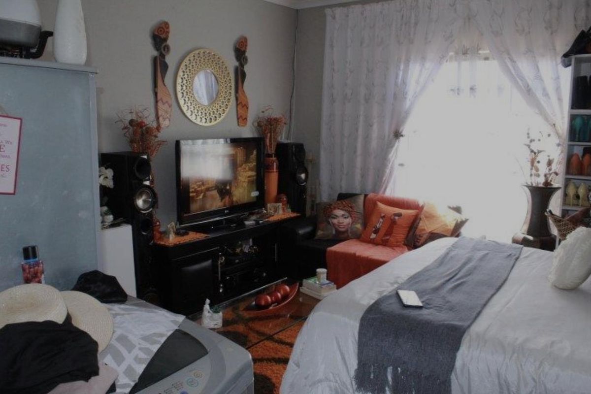 A bedroom featuring a window with curtains and neutral wall finishes.