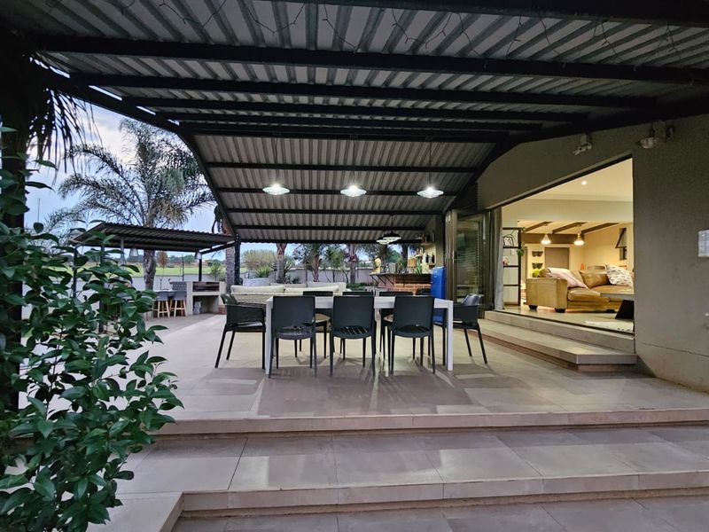 Spacious covered patio featuring tiled flooring, a built-in bar, and seamless access to the interior living area through large sliding glass doors.