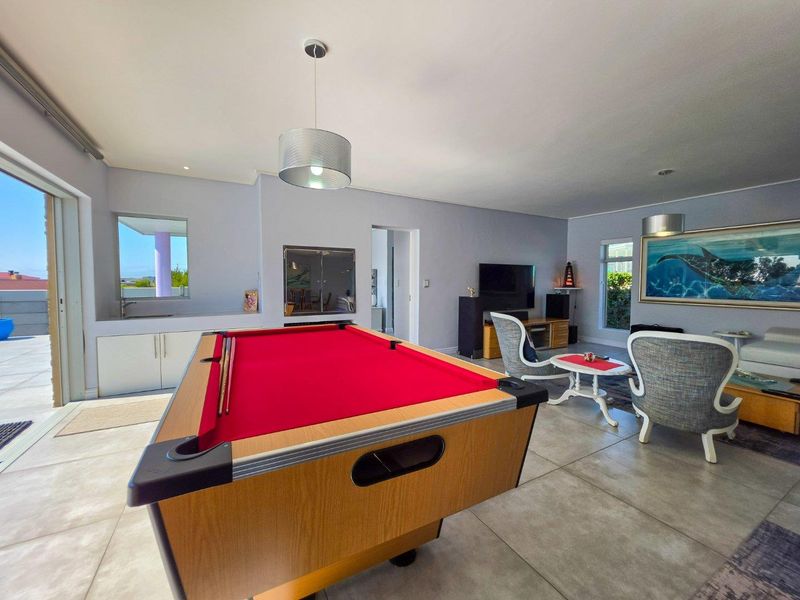 Spacious living area featuring large format floor tiles, a built-in wet bar, and direct access to an outdoor patio through sliding glass doors.