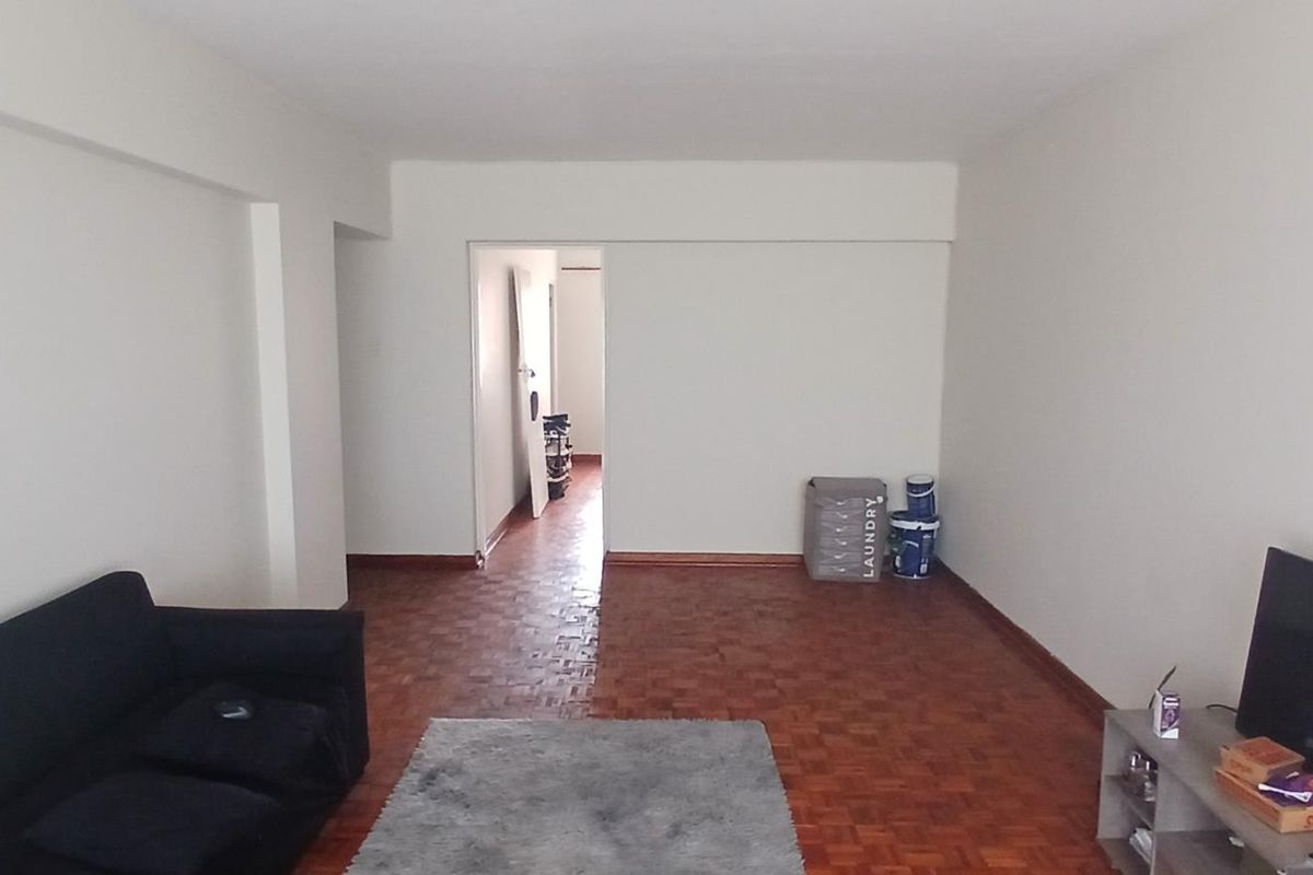 A living room featuring classic parquet flooring and neutral walls, offering a blank canvas for interior design updates.