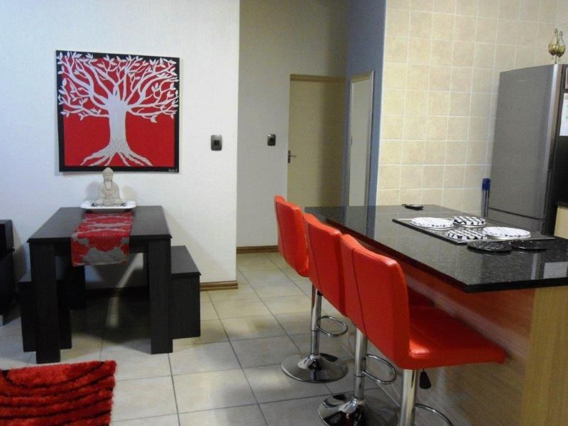 Open plan kitchen and dining area featuring a granite island with built-in hob and tiled flooring throughout.