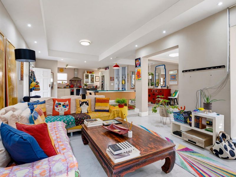 Spacious open-plan living area featuring a connected kitchen, recessed ceiling lighting, and neutral tiled flooring throughout the main living space.