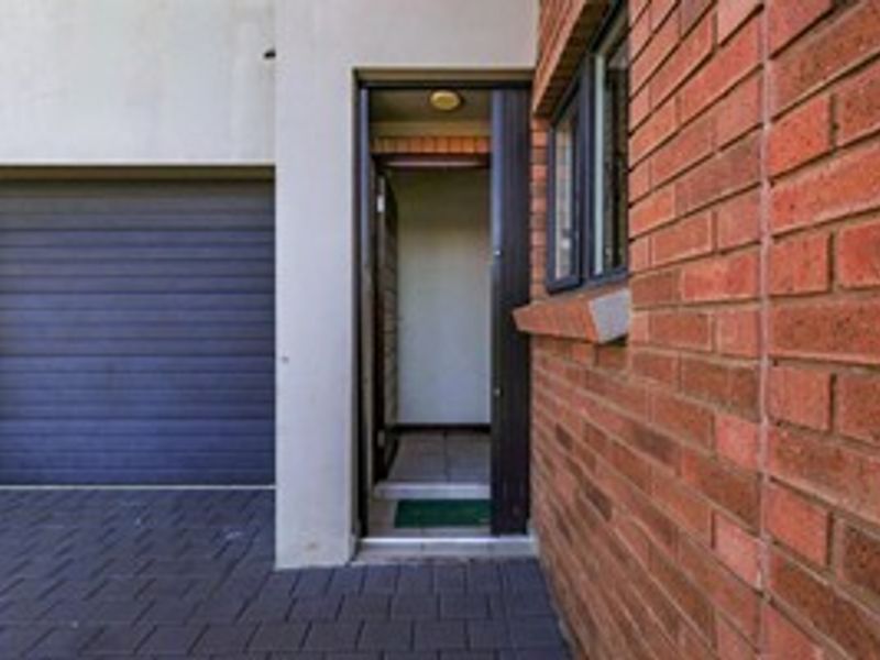 Front exterior view showing a paved driveway, a garage door, and the main entrance to the property.
