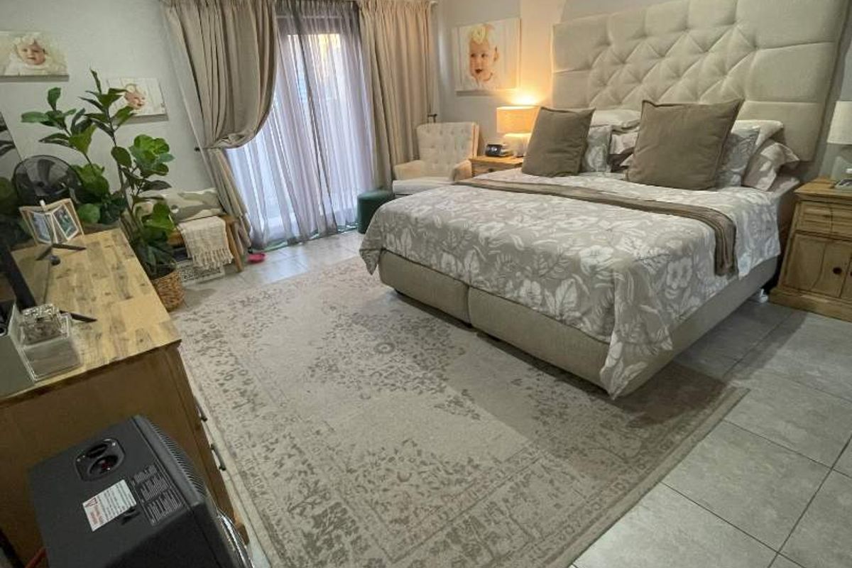 Spacious bedroom featuring tiled flooring, recessed ceiling lighting, and a large sliding door providing access to the outdoor area.
