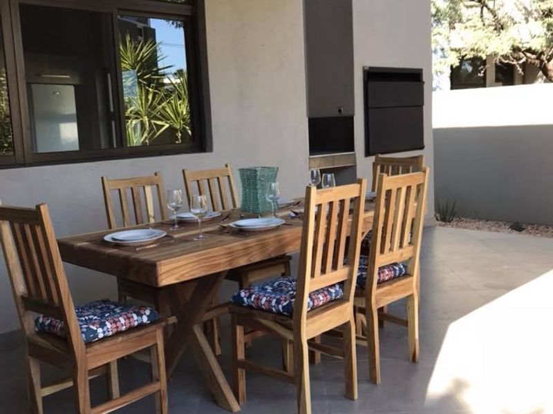 A covered patio area featuring tiled flooring and a built-in braai, perfect for outdoor dining and entertaining.
