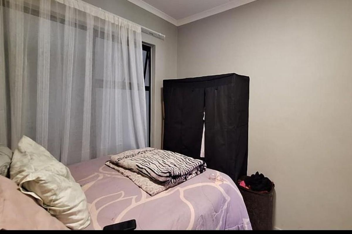 A standard bedroom featuring neutral wall finishes and a window with curtain track.
