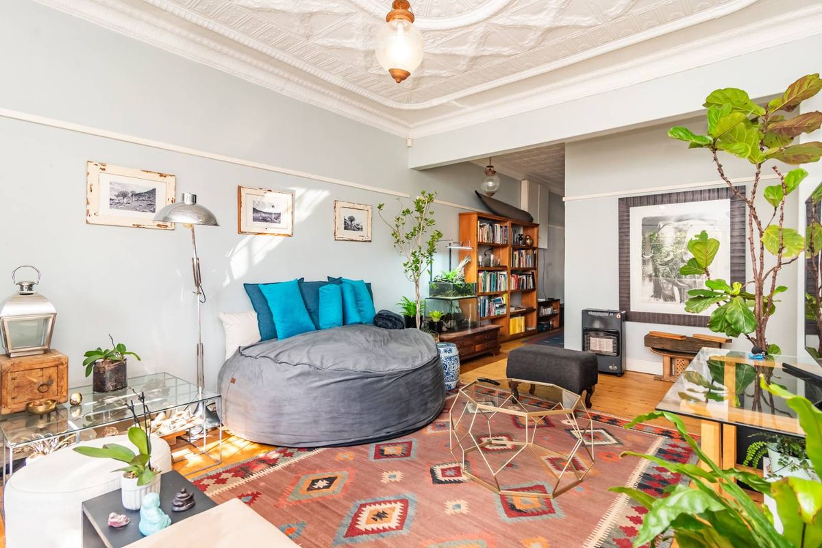A character-filled living room featuring original ornate pressed metal ceilings, timber flooring, and classic picture rails, offering a warm and inviting atmosphere.