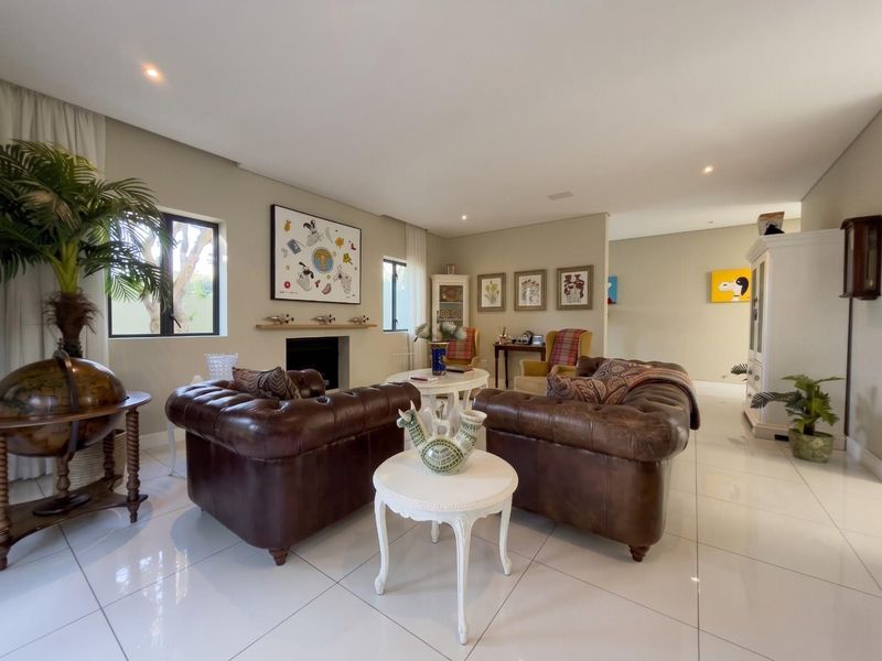 Spacious living room featuring polished tiled flooring, recessed downlights, and a built-in fireplace, creating a comfortable and well-maintained atmosphere.