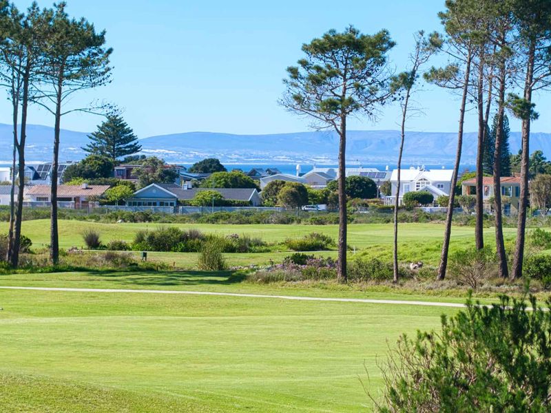 A scenic view overlooking a well-maintained golf course with mature trees and residential properties in the background.