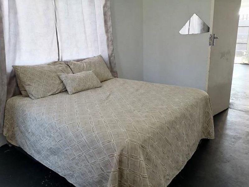 A bedroom featuring neutral wall tones and basic flooring, requiring minor cosmetic updates to improve the overall aesthetic and finish.