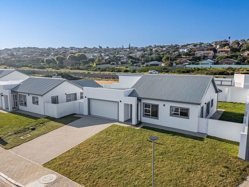 Aerial view of a modern residential property featuring a paved driveway, garage, and well-maintained lawn in a suburban estate setting.