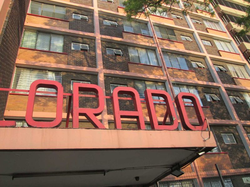 Exterior view of the apartment building facade featuring brick construction and prominent building signage.