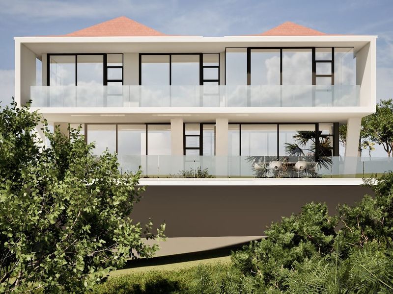 A modern two-story residential building featuring expansive glass sliding doors and sleek glass balustrades on the upper and lower balconies.