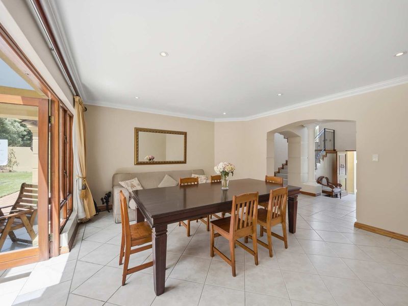 Spacious dining area featuring tiled flooring, recessed lighting, and large wooden sliding doors providing seamless access to the outdoor patio area.