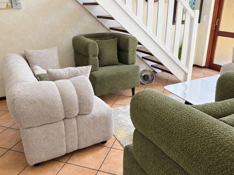 A living room area featuring terracotta floor tiles and an integrated staircase, providing access to the upper level of the apartment.