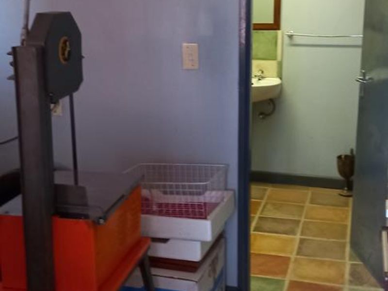 A utility space featuring multi-colored tiled flooring and access to an adjoining bathroom area.