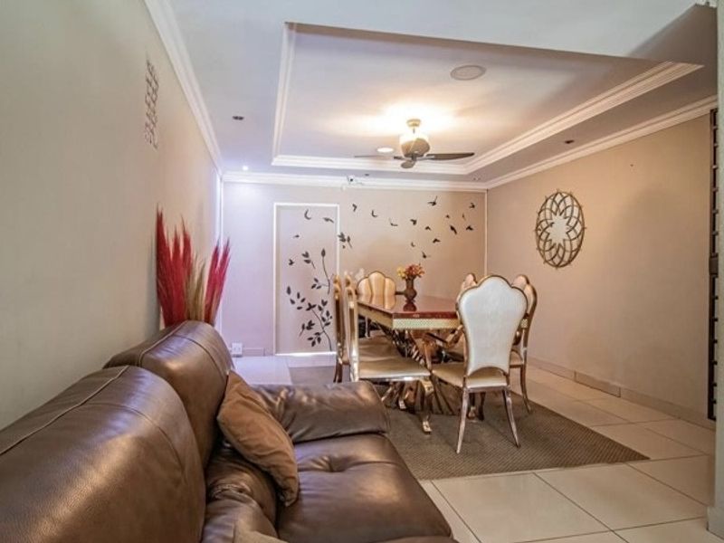 Open plan living and dining area featuring tiled flooring, recessed ceiling with cove molding, and a ceiling fan.