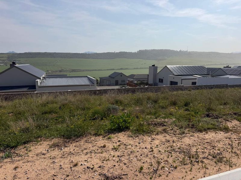 A scenic view overlooking the surrounding residential estate and open landscape from the vacant residential plot.