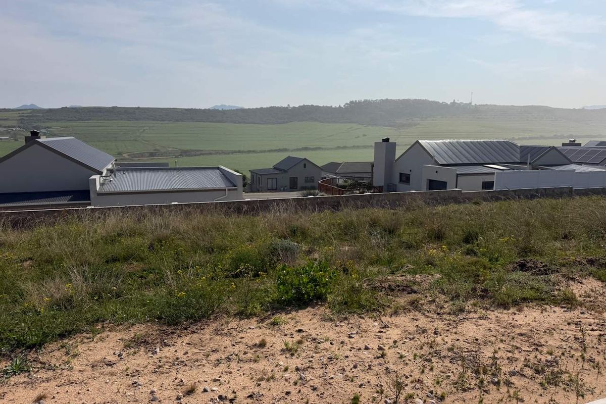 A scenic view overlooking the surrounding residential estate and open landscape from the vacant residential plot.