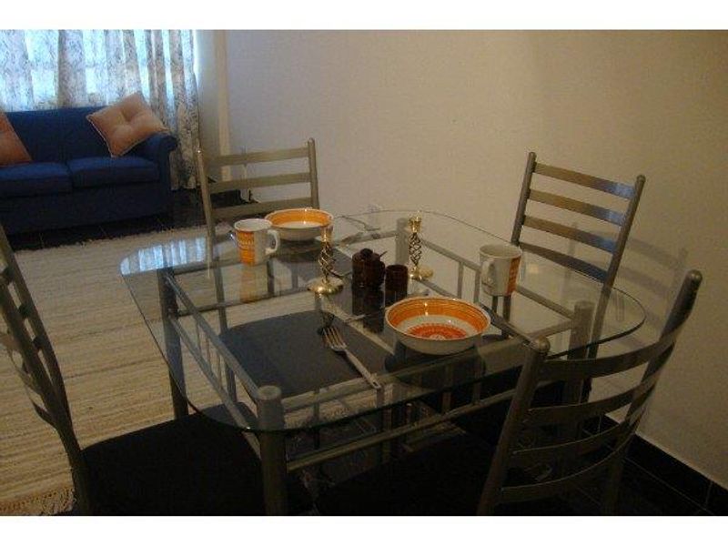 A dining area featuring tiled flooring, visible in an apartment setting.