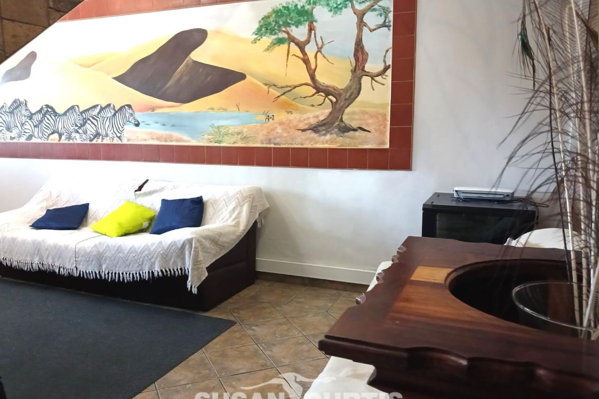 A living area featuring tiled flooring and a large decorative wall mural framed by ceramic tiles.