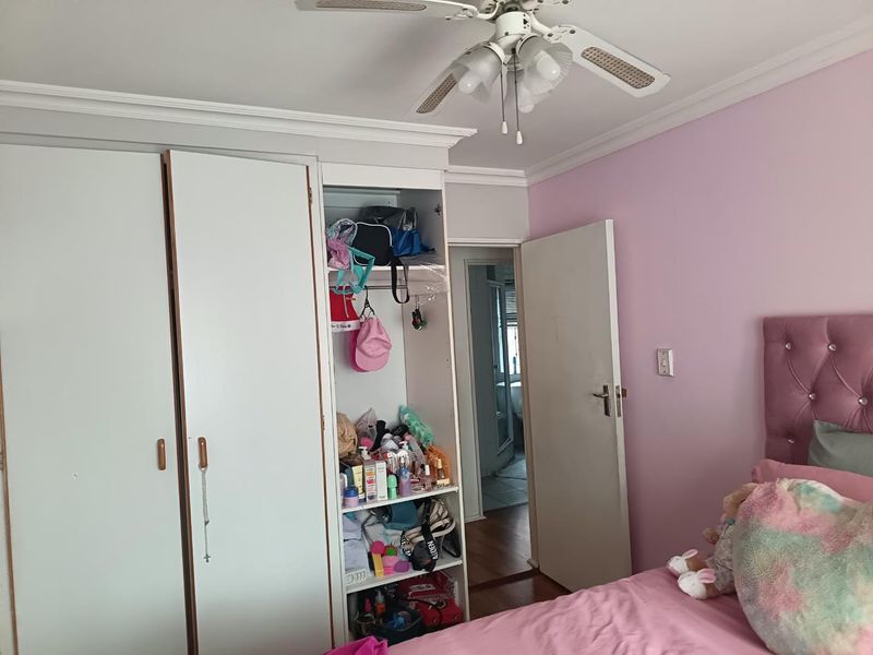 Bedroom featuring built-in cabinetry, crown molding, and a ceiling fan, with direct access to an adjoining room.