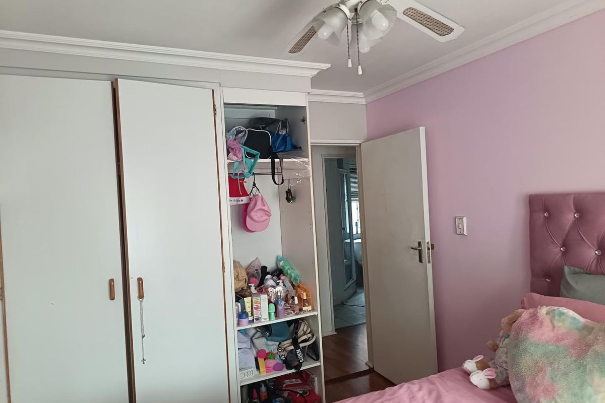 Bedroom featuring built-in cabinetry, crown molding, and a ceiling fan, with direct access to an adjoining room.