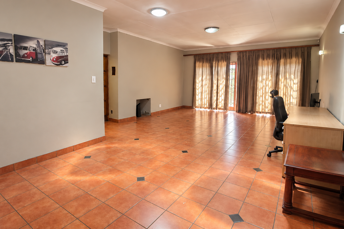 Spacious living area featuring terracotta floor tiles, recessed lighting, and large sliding glass doors that provide ample natural light.