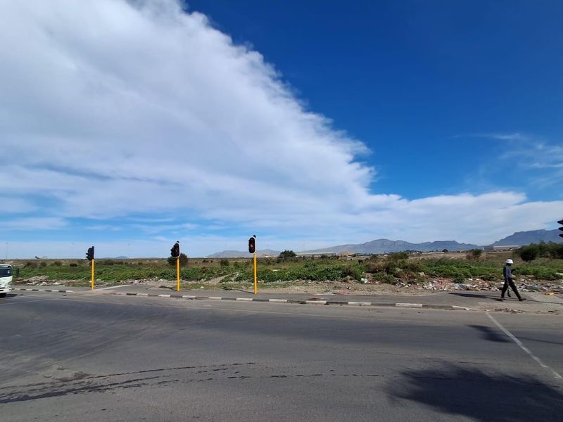 Street view of the vacant agricultural land showing road access, traffic infrastructure, and surrounding landscape.