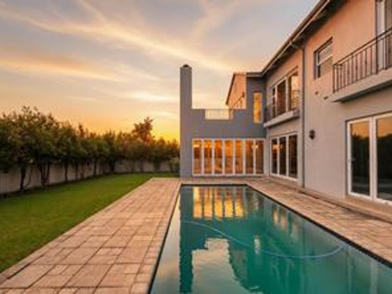 A well-maintained rear exterior featuring a swimming pool, paved patio area, and direct access to the home via large sliding glass doors.