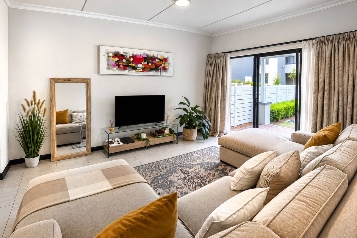 Bright and well-maintained living room featuring large sliding glass doors that provide seamless access to the outdoor patio area.