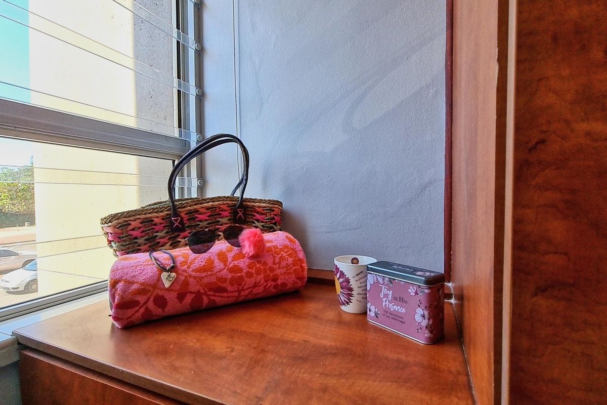 A corner view of a bedroom featuring built-in wooden cabinetry and a large window with an exterior street view.