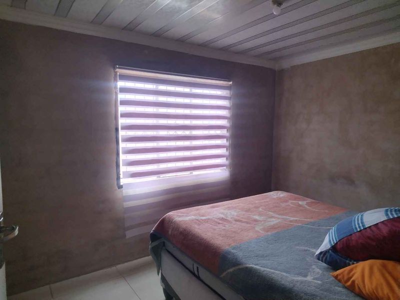 A bedroom featuring unfinished wall surfaces and ceiling paneling, providing a blank canvas for interior design updates.