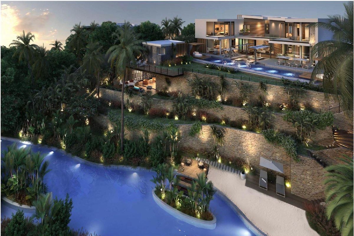 An elevated aerial view of a luxury multi-level estate featuring terraced stone retaining walls, a swimming pool, and landscaped gardens leading to a water feature.