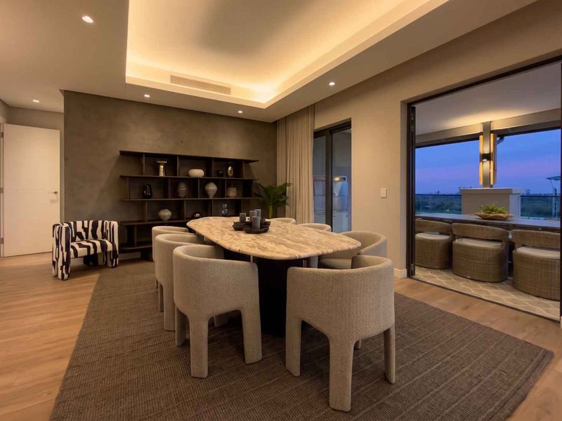 Elegant dining room featuring recessed cove lighting, built-in shelving, and large sliding glass doors opening to an outdoor patio area.