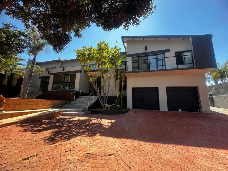 Modern double-story residence featuring a paved driveway, double garage, and an elevated balcony with contemporary architectural finishes.
