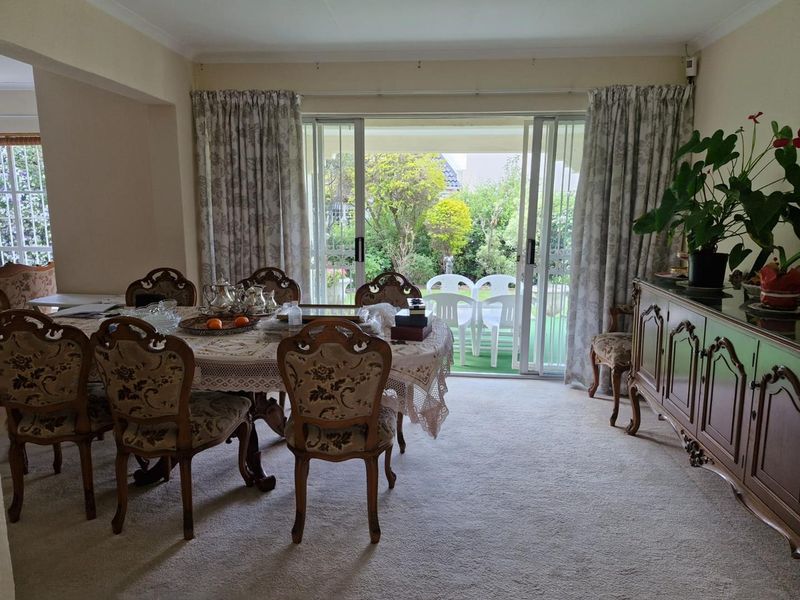 Dining room featuring carpet flooring and large sliding glass doors providing access to the rear garden area.