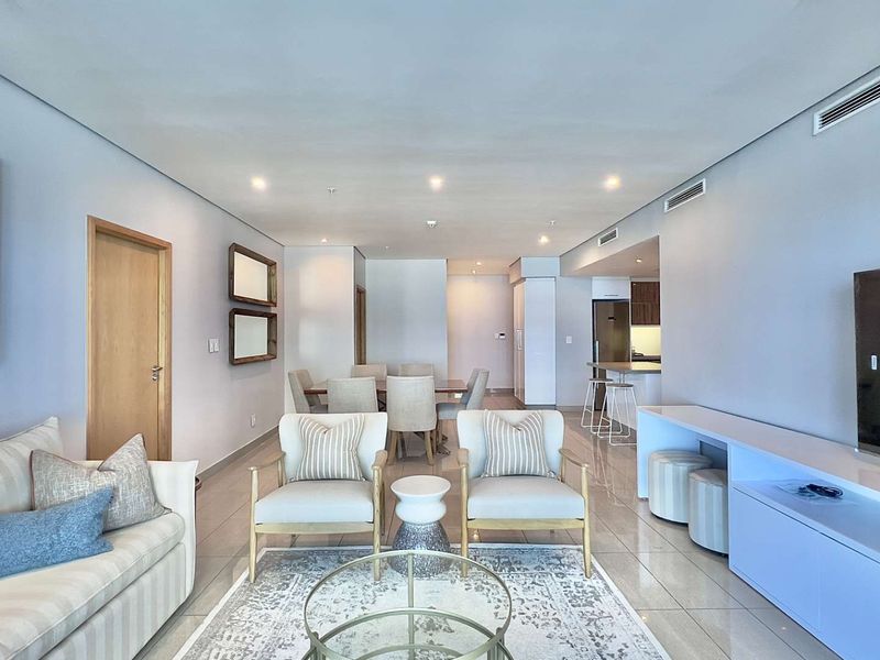 Spacious open-plan living and dining area featuring tiled floors, recessed lighting, ducted air conditioning, and a modern integrated kitchen.