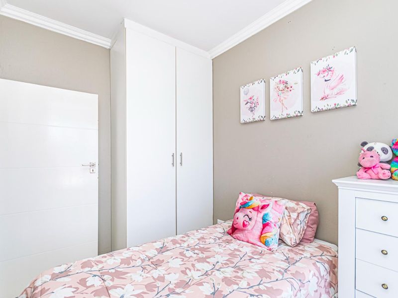 A well-maintained bedroom featuring a built-in wardrobe and decorative crown molding, providing a clean and functional living space.