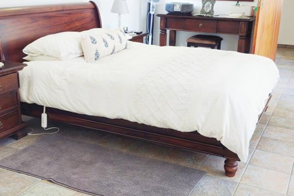 A bedroom featuring tiled flooring and a neutral wall finish, providing a functional and well-lit sleeping space.