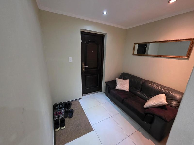 A functional entrance foyer featuring tiled flooring, recessed downlighting, and a solid core entrance door.