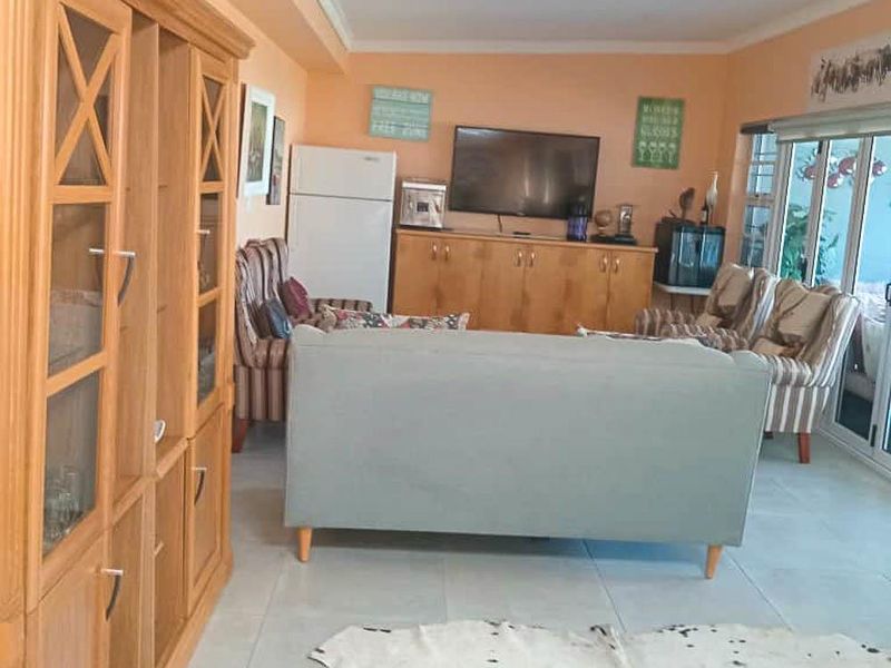 A living room featuring tiled flooring and sliding glass doors leading to an outdoor area, with built-in cabinetry providing storage.