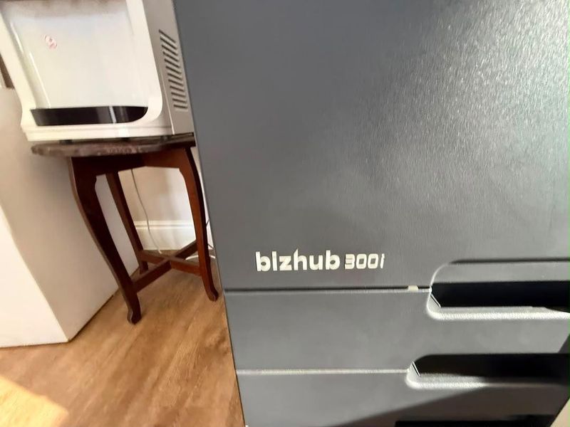 A close-up view of a commercial office printer located within an office workspace.