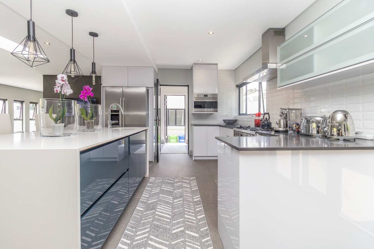Modern kitchen featuring a central island, sleek cabinetry, integrated stainless steel appliances, and high-quality finishes with a clean, contemporary aesthetic.