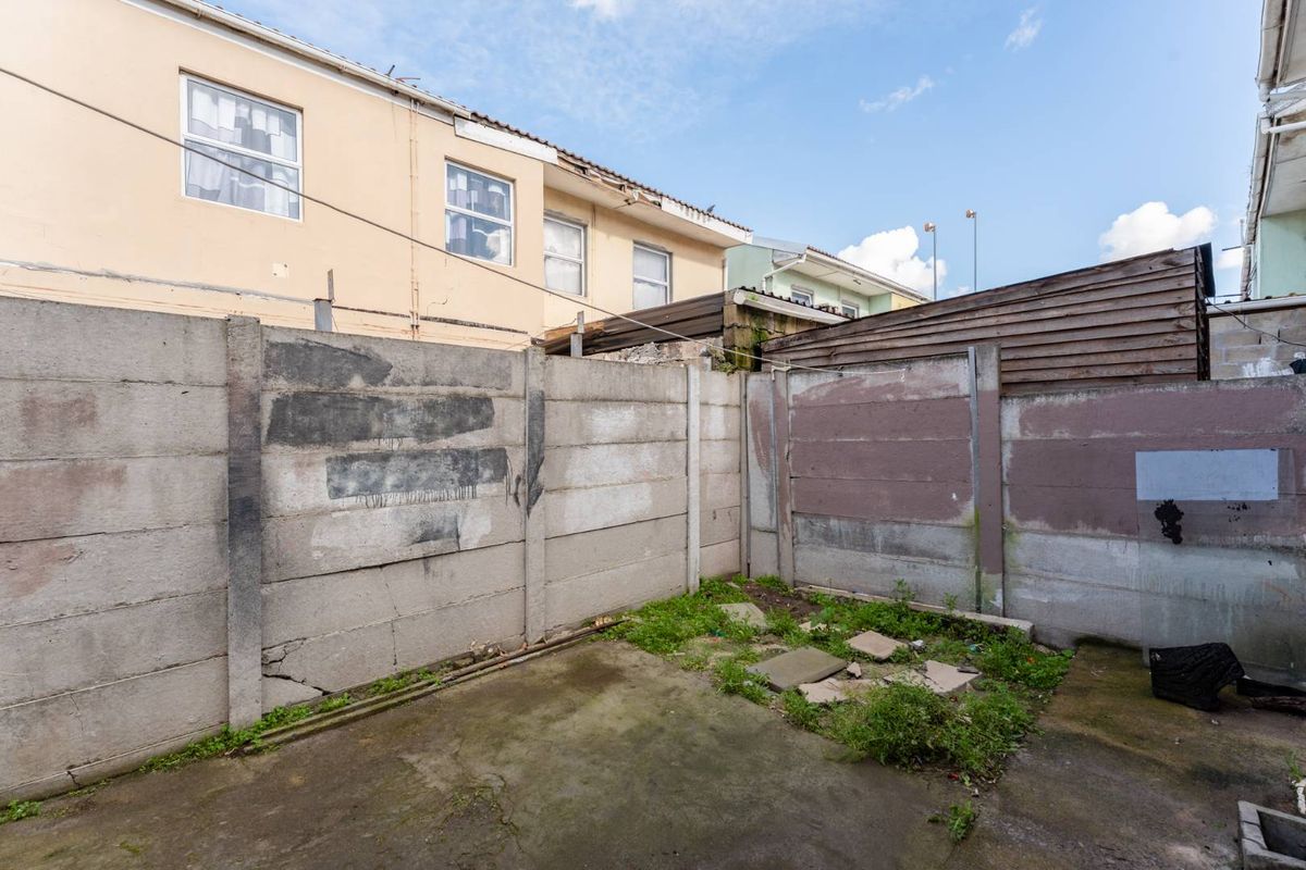 A small, enclosed rear courtyard area featuring concrete paving and boundary walls, requiring maintenance and landscaping to improve the outdoor space.