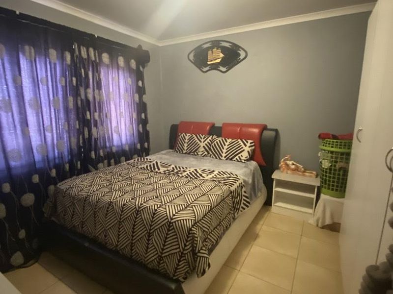 A bedroom featuring tiled flooring, a built-in wardrobe, and cove cornice detailing.