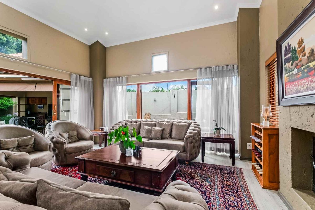 Spacious living room featuring high vaulted ceilings, recessed lighting, and large sliding glass doors providing seamless access to the outdoor patio area.