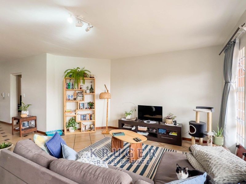 A spacious living room featuring ceramic tile flooring and neutral walls, offering a comfortable and functional layout for relaxation.